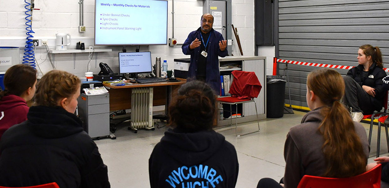 Teacher speaking to group of young people